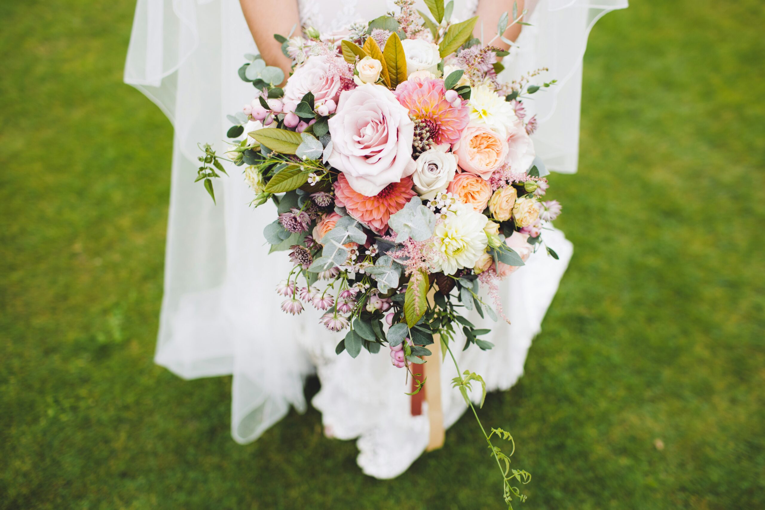 A person holding a brides bouquet.
